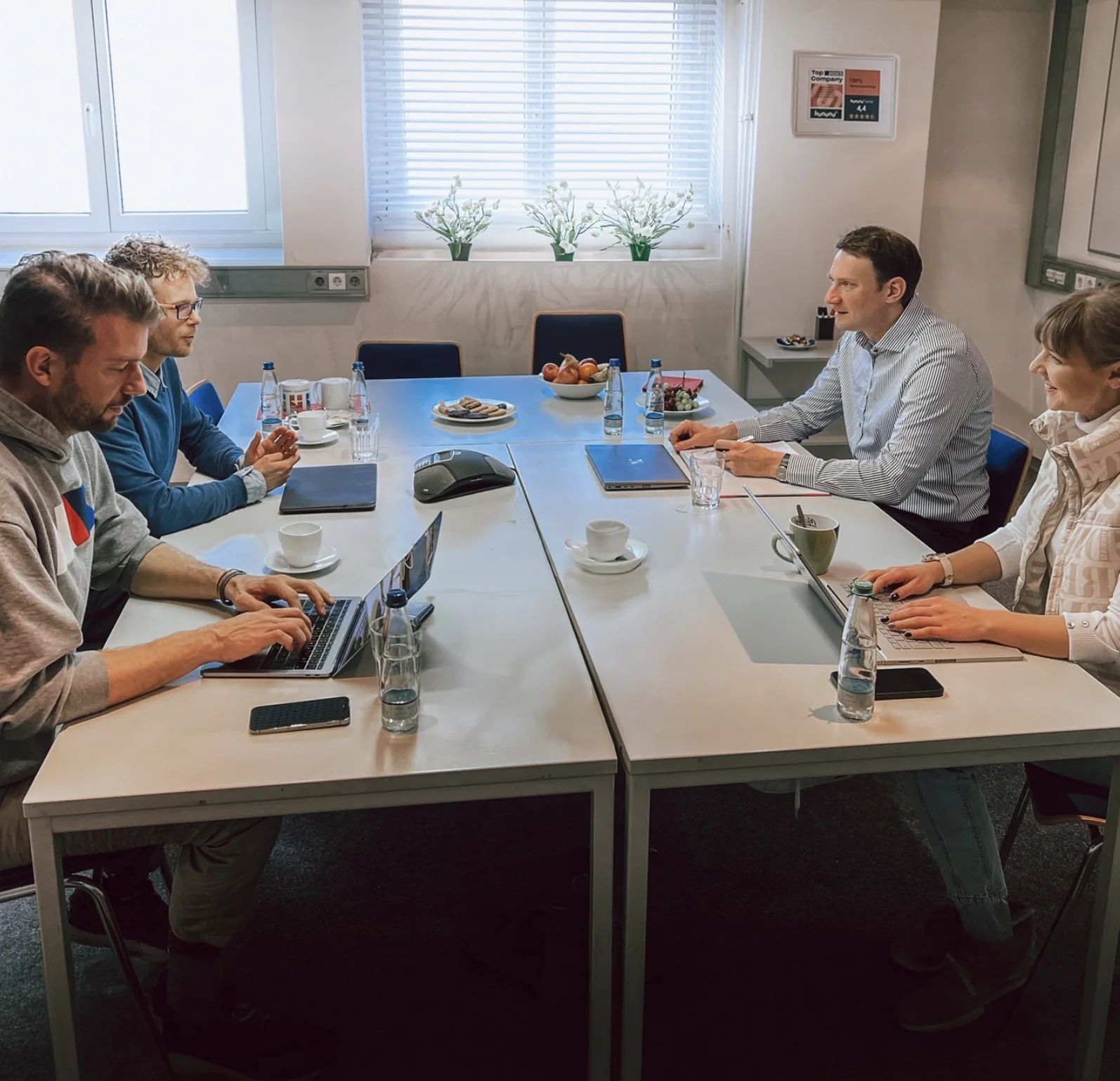 Gruppe sitzt an einem gedeckten Besprechungstisch