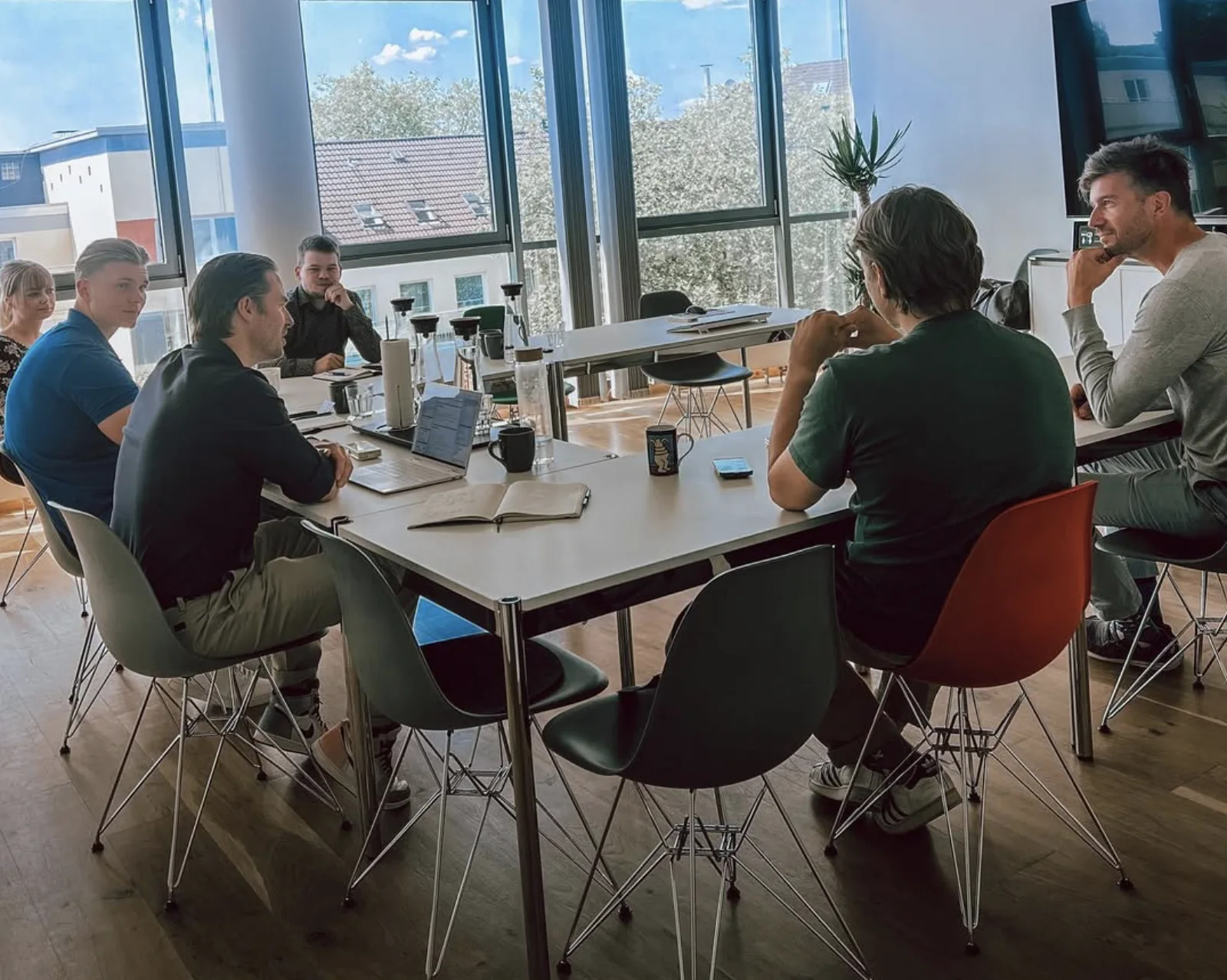 Besprechung mit mehreren Menschen an einem Tisch