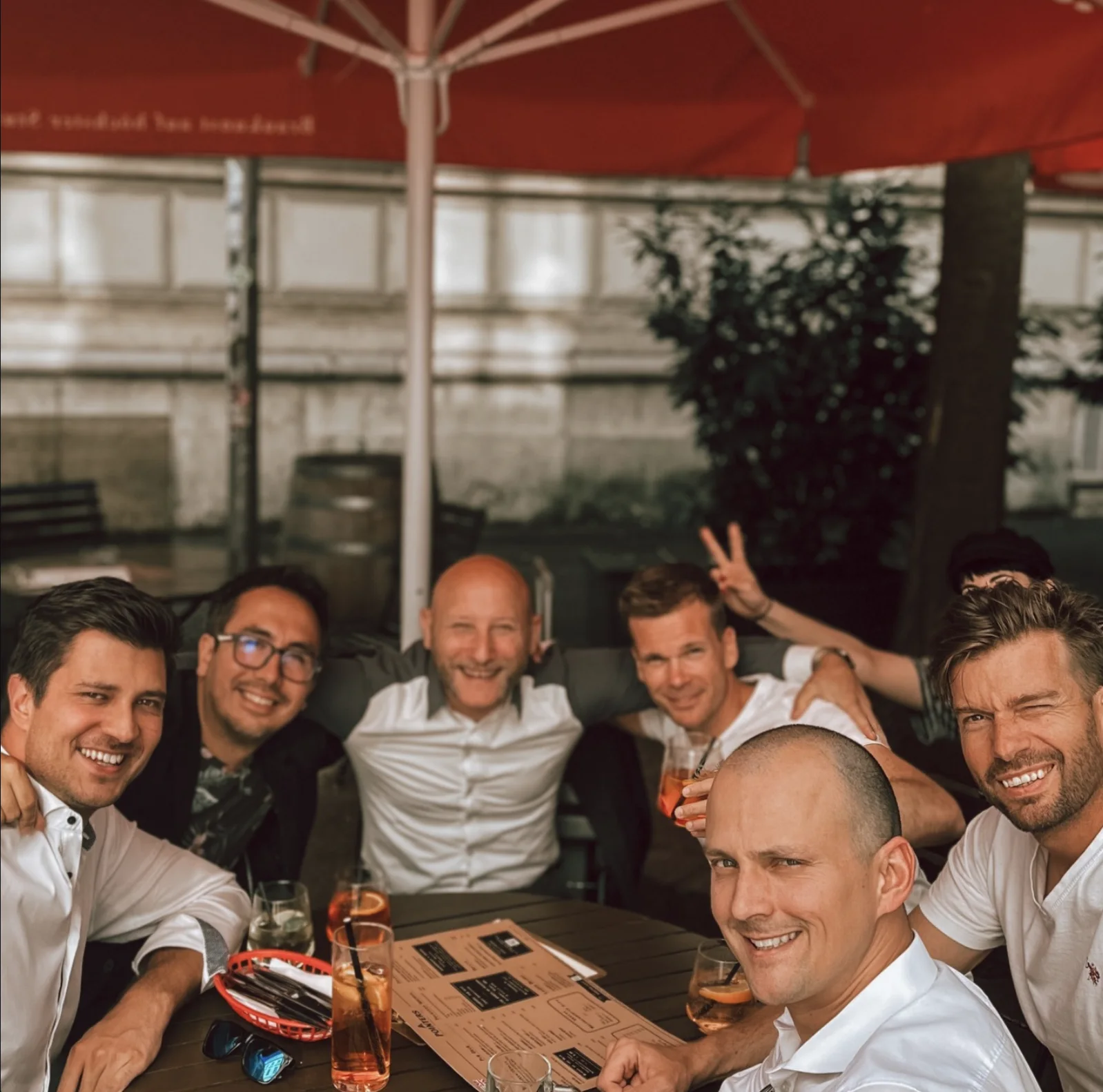 Gruppe sitzt gemeinsam an einem Tisch im Freien