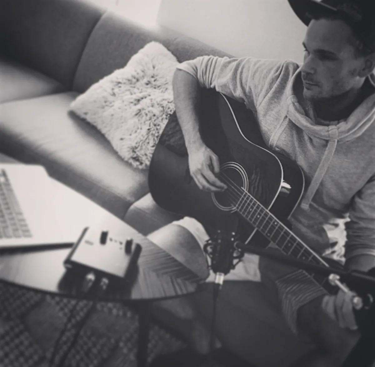Marcel spielt Gitarre auf dem Sofa