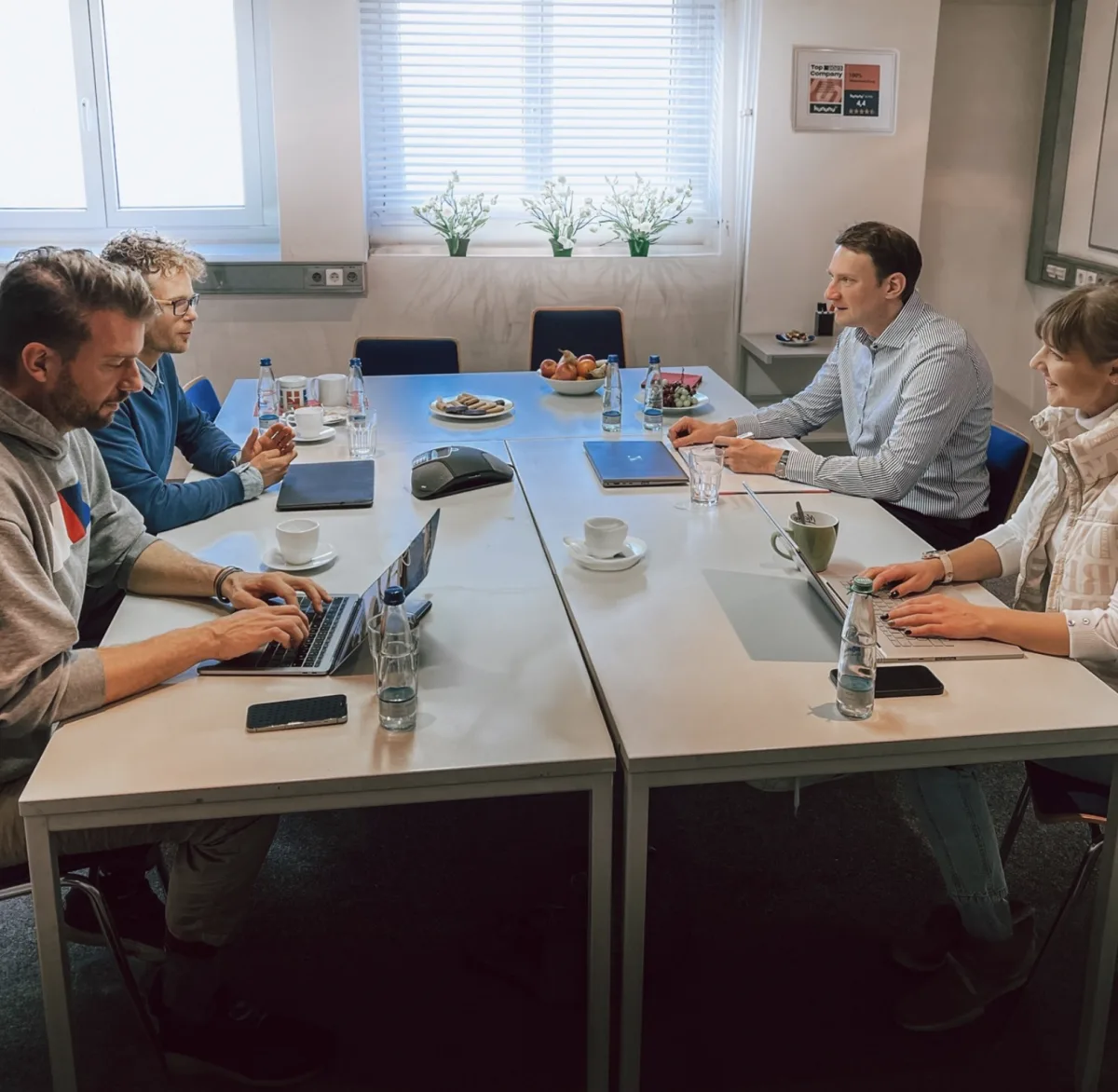 Besprechung an einem weißen Konferenztisch