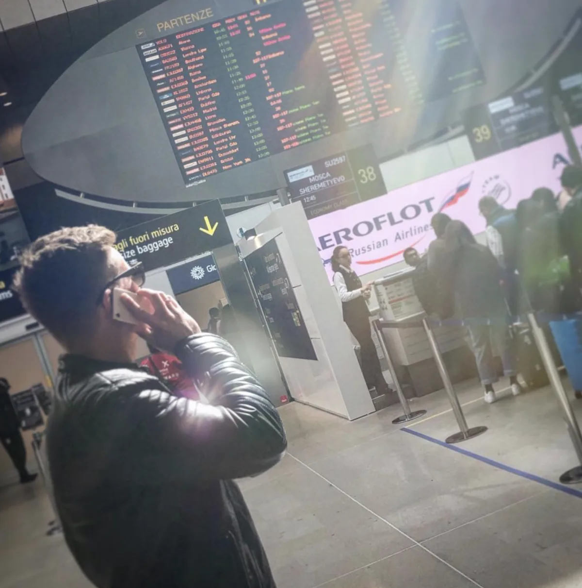 Marcel telefoniert an einem Flughafen